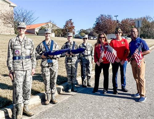 veterans including Board member Alice Lessmann standing with ROTC honor guard